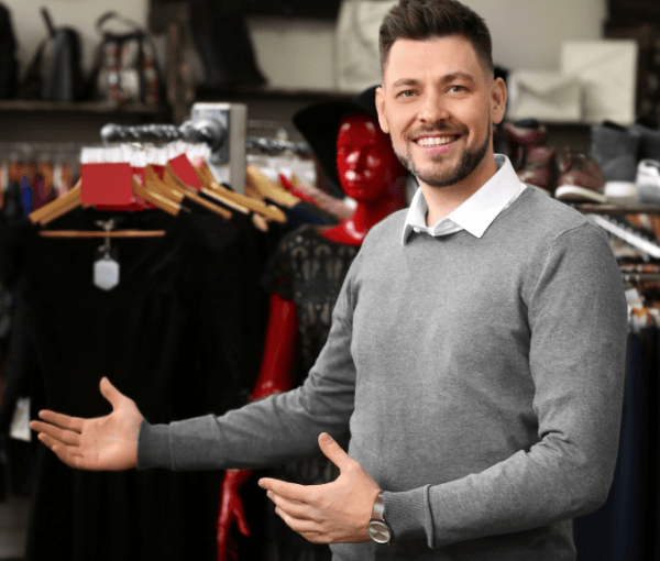A man standing in front of clothing who is opening a Clothing Boutique